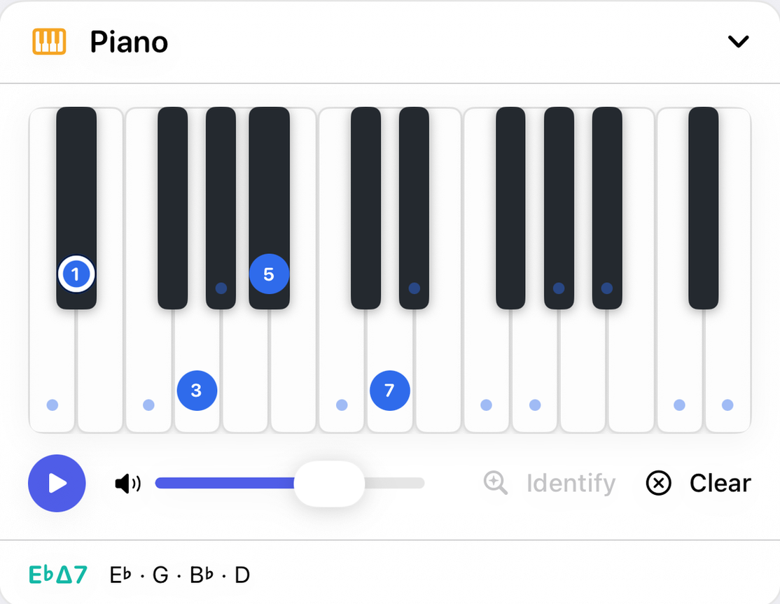 The Piano panel on iPhone showing E-flat major seventh, with markers numbered 1, 3, 5 and 7 on the keys and small dots on the keys of the key